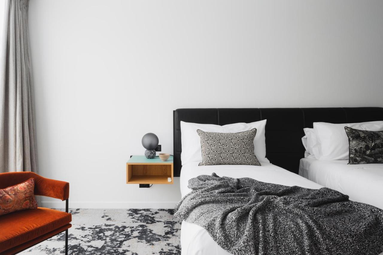 Ebb-Dunedin Exterior foto A bedroom with a bed, a chair and a nightstand